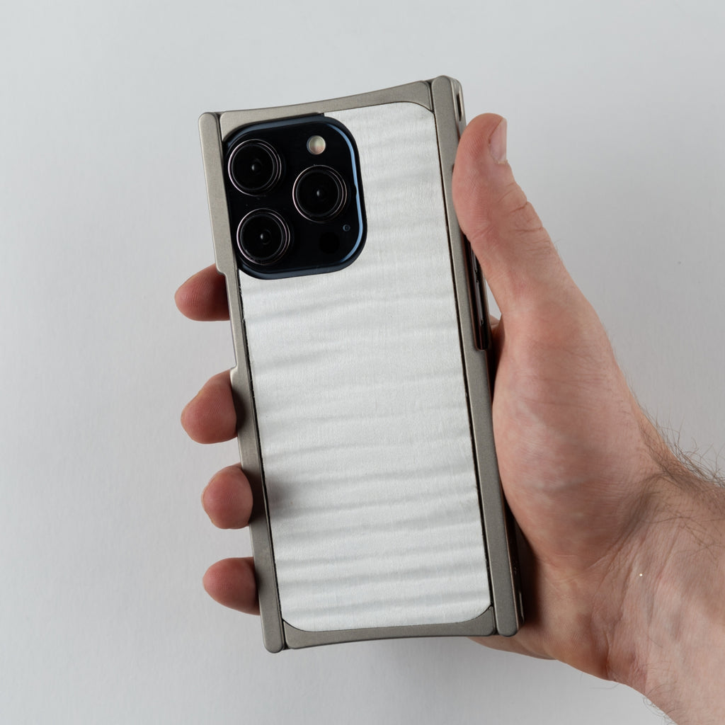 titanium iphone case with g10 white back in hands of a person