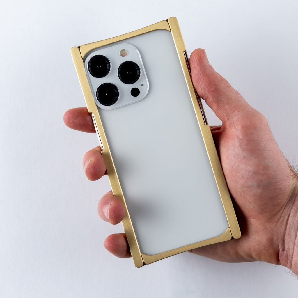 brass cage iphone case in hand