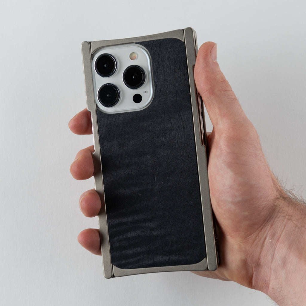 titanium iphone case with black back wood in hand of a person